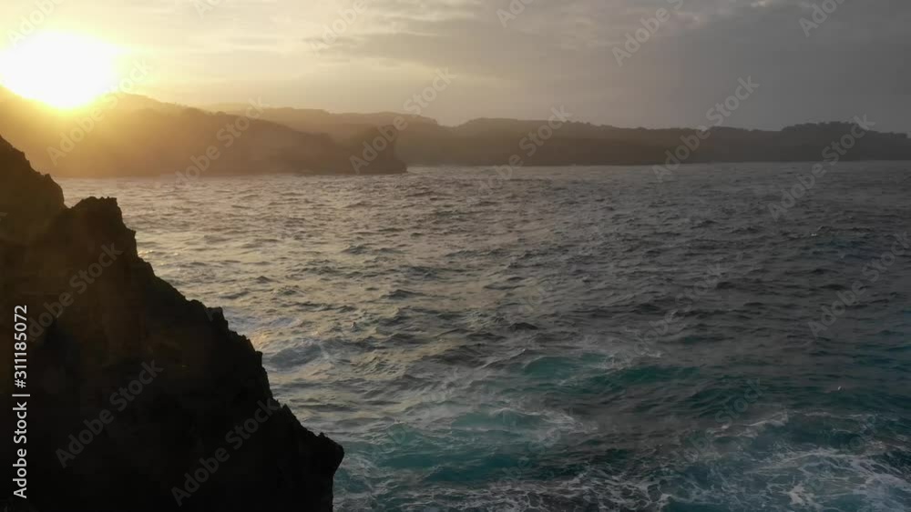 Angel's Billabong – This crystal clear tide pool, East coast of Nusa Penida, Bali, Indonesia, aerial shot revealing beautiful sunset behind the cliffs Angel's Billabong – This crystal clear tide pool, East coast of Nusa Penida, Bali, Indonesia, aerial shot revealing beautiful sunset behind the cliffs
