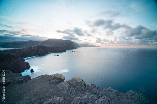 Volcanic cliffs. Rocky coastline in peninsula Ponta de Sao Lourenco during sunset, long exposore gave smooth sea water. Seashore in Portuguese island Madeira in the autumn.