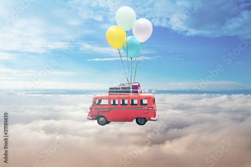 Flying bas toy with the colourful balloons at the blue sky 