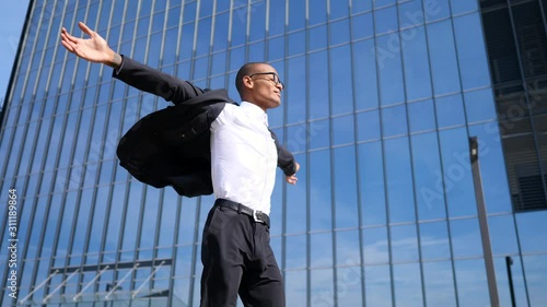 Young Businessman With Arms Wide Open Walking In City photo