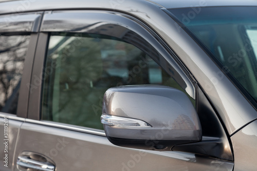 Close-up of the side left mirror with rear veiw 3d camera and window of the car body gray SUV on the parking after washing in auto service industry. Road safety while driving © Aleksandr Kondratov