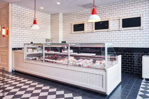 Interior display showcase of a delicatessen shop with cheese, sausages and dairy products