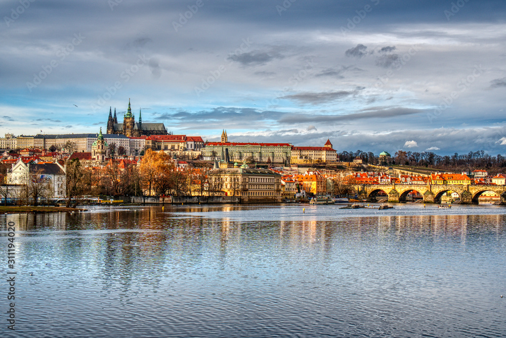 historical part of prague with castle and cathedral and charles bridge beautifully lit by sunset, czech prague