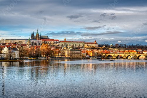 historical part of prague with castle and cathedral and charles bridge beautifully lit by sunset, czech prague