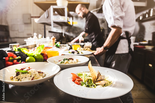 Fotografia, Obraz Professional chef cooking in the kitchen restaurant at the hotel, preparing dinner