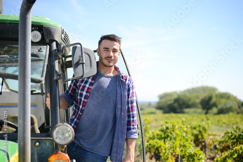 handsome man farmer in the field driving a tractor agriculture agronomy business equipment