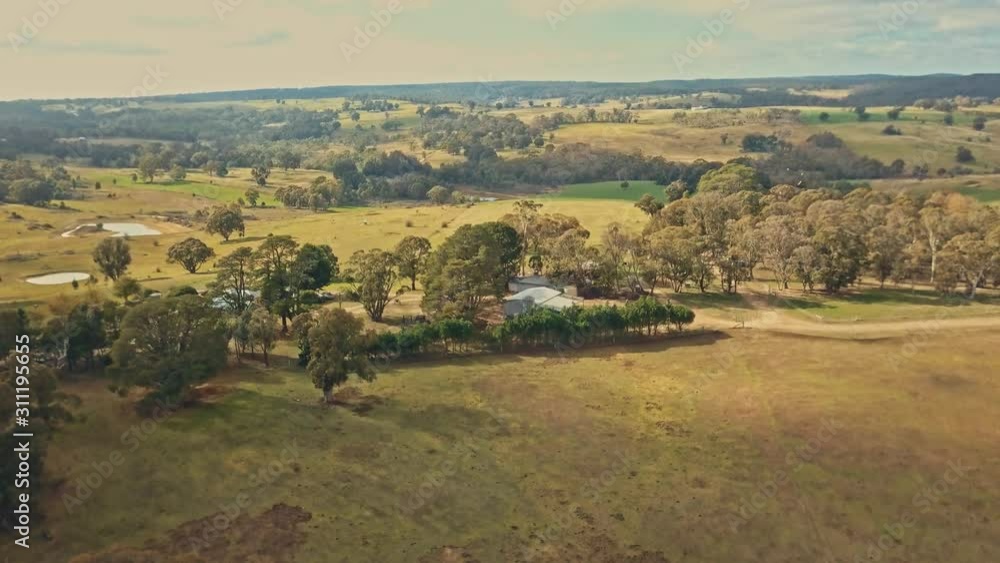 An aerial shot of stunning and idyllic farmland with rolling hills, lush fields and golden sunlight An aerial shot of stunning and idyllic farmland with rolling hills, lush fields and golden sunlight