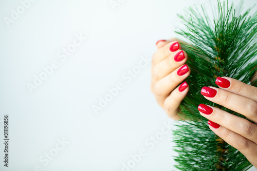 Red Christmas manicure make in beauty studio on Christmas background