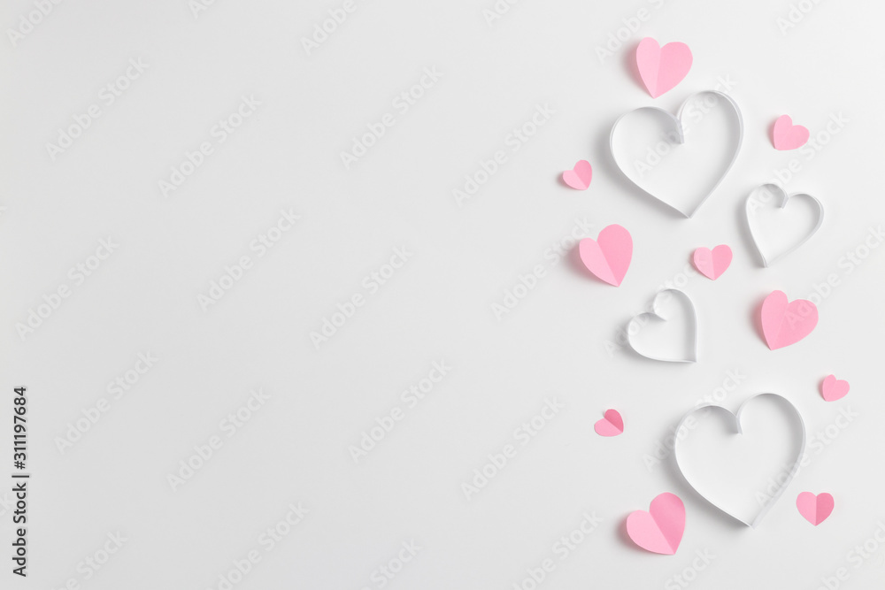 Composition for Valentine's Day February 14th. Delicate composition of pink hearts made of paper on a white background. Heart cut out of paper. Greeting card. Flat lay, top view, copy space. Composition for Valentine's Day February 14th. Delicate composition of pink hearts made of paper on a white background. Heart cut out of paper. Greeting card. Flat lay, top view, copy space.