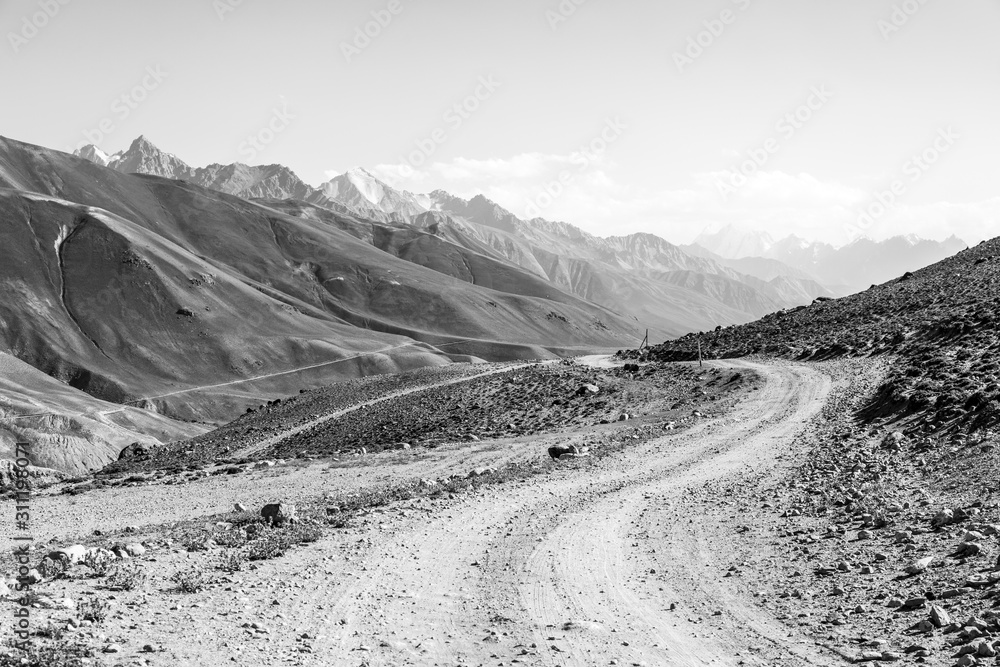 Pamir Highway in the desert landscape of the Pamir Mountains in Tajikistan. Afghanistan is on the left