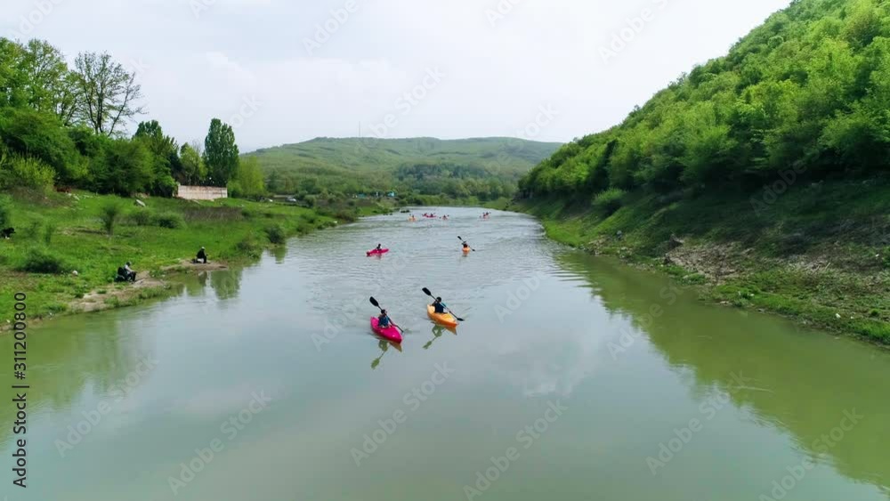 Group of friends kayak towards frame, aerial pullback along river Drin in Kosovo Group of friends kayak towards frame, aerial pullback along river Drin in Kosovo