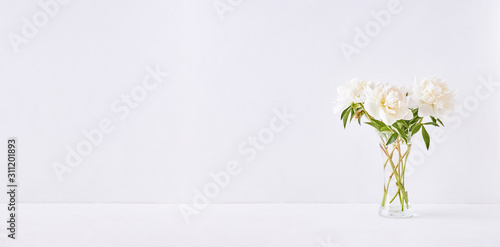 Home interior with decor elements. White peonies in a vase on a white background