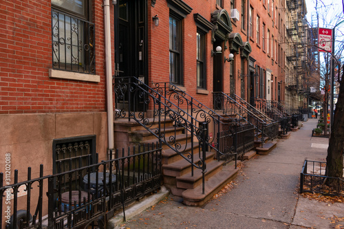 Row of Old Brick Residential Buildings along the Sidewalk in Hell's Kitchen New York © James