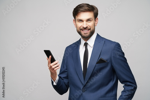 businessman holding phone isolated over grey background