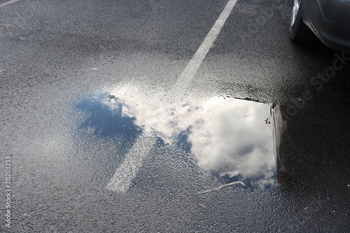 Abstract puddle cloud reflection on street pavement