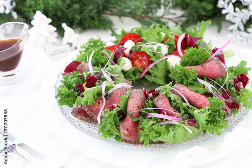 Holiday salad with roast beef on christmas decoration background Holiday salad with roast beef on christmas decoration background
