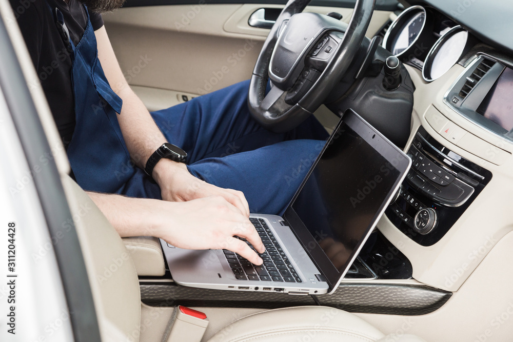 Professional car mechanic working in auto repair service. Computer video investigate. Engine diagnostics. Service station. Professional car mechanic working in auto repair service. Computer video investigate. Engine diagnostics. Service station.