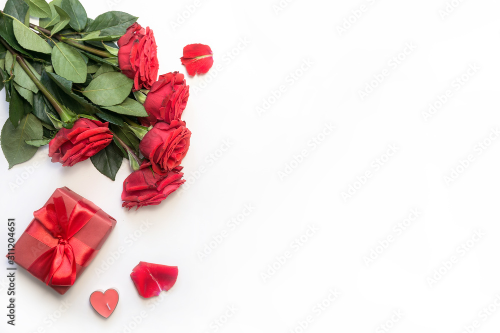 Romantic table setting with bouquet of red roses and gift. View from above. Valentine day. Romantic table setting with bouquet of red roses and gift. View from above. Valentine day.