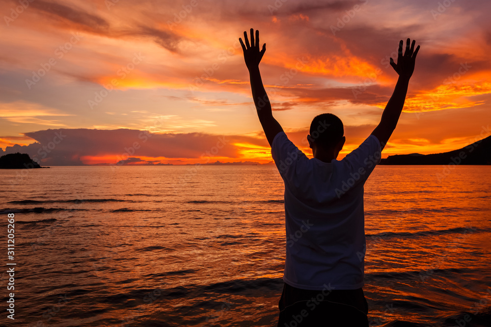 Happy Man with hands up on sandy beach watching Sea, mountain and cloud in the sea on sunset times. Background, close up