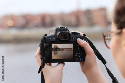 Young female photographer taking picture with camera