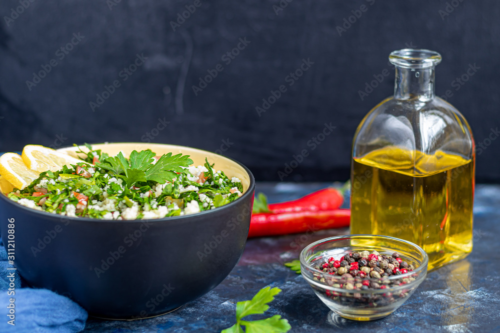 Tabbouleh salad in a round plate on a dark blue background. Tabbouleh salad in a round plate on a dark blue background.