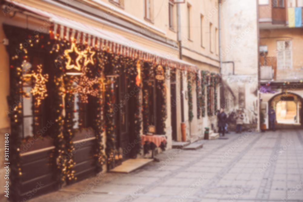 Defocused background. Beautiful empty street at Christmas, decorated restaurant with lights and garlands