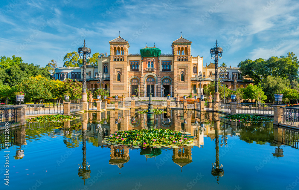 Naklejka premium Museum of Popular Arts and Traditions reflecting in the near fountain in Seville, Andalusia, Spain.