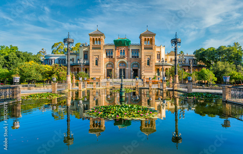 Museum of Popular Arts and Traditions reflecting in the near fountain in Seville, Andalusia, Spain.