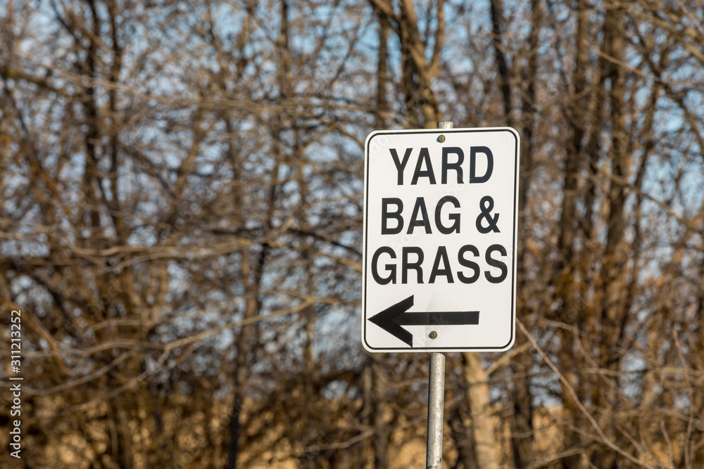 Leaf, yard bag, and grass clippings direction sign with arrow at city yard waste disposal, dump site