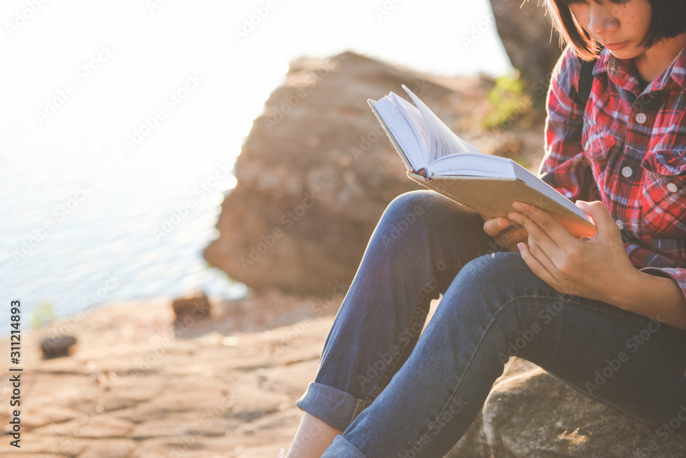Pretty relaxed young woman reading a book in quiet nature, concept read a books.
