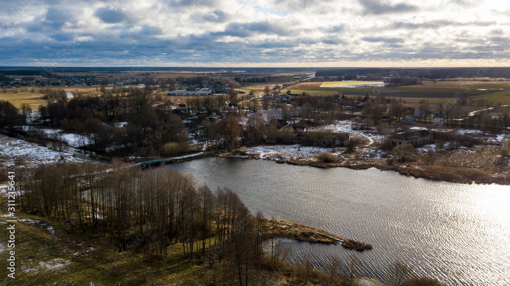 Beautiful winter lake on cloudy sky background. Aerial view.
