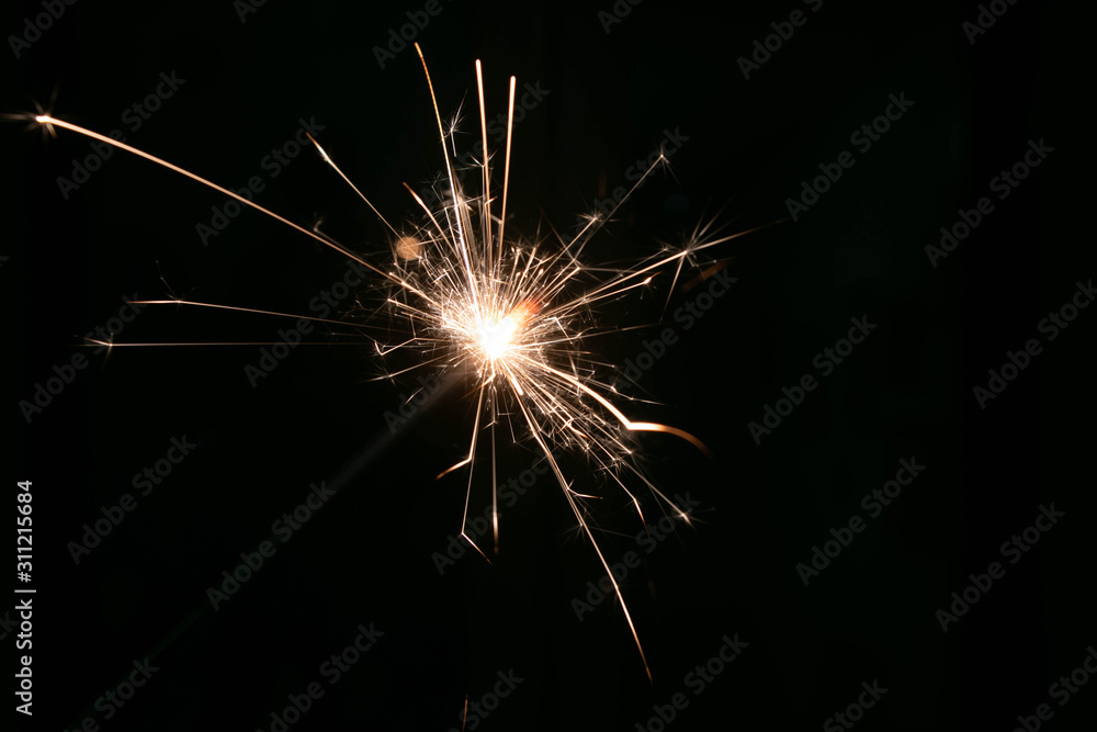 sparks from a lit sparkler on a dark background