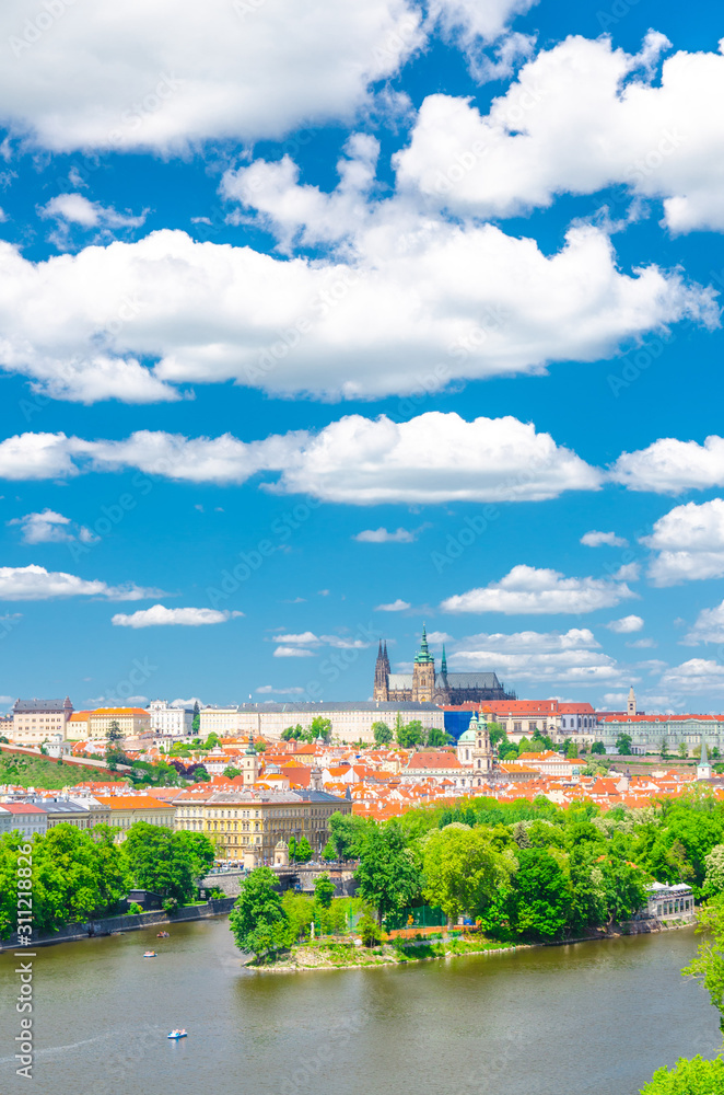 Obraz premium Aerial vertical view of Prague city, historical center with Prague Castle, St. Vitus Cathedral in Hradcany district, Strelecky island, Vltava river, blue sky white clouds, Bohemia, Czech Republic