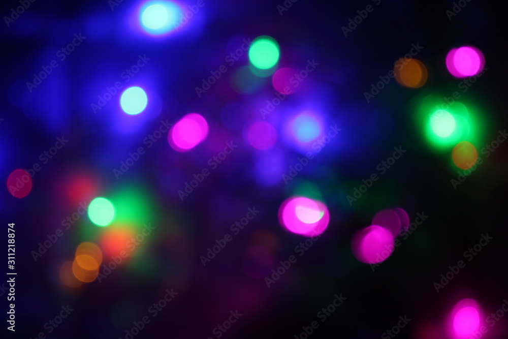 An out of focus photograph of Christmas lights.   Bokeh background texture, festive concept.