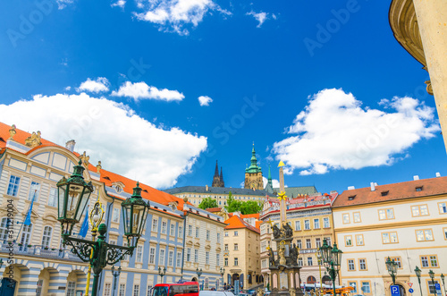 Academy of Performing Arts, Column of the Holy Trinity and street lights on square in Mala Strana district, St. Vitus Cathedral spire, blue sky white clouds background, Bohemia, Czech Republic