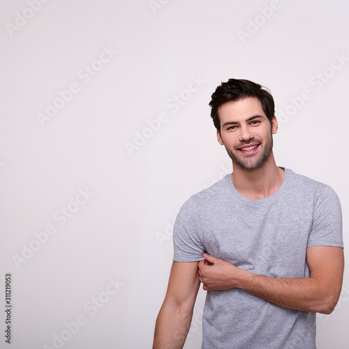 Smiling happy sports young guy in a gray T-shirt.