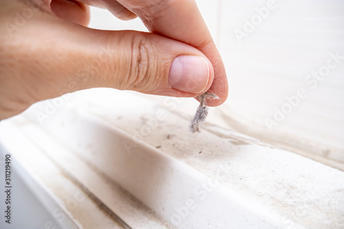 A hand taking a piece of dust from furniture, dusty home house concept