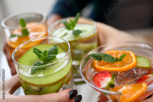 Group friends hold fruit cocktails in hand closeup