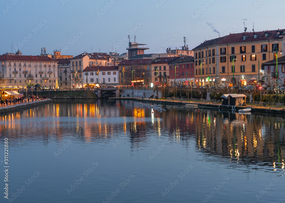 the houses of the characteristic Navigli district are reflected in the dock (Darsena) after sunset.Milan - Italy