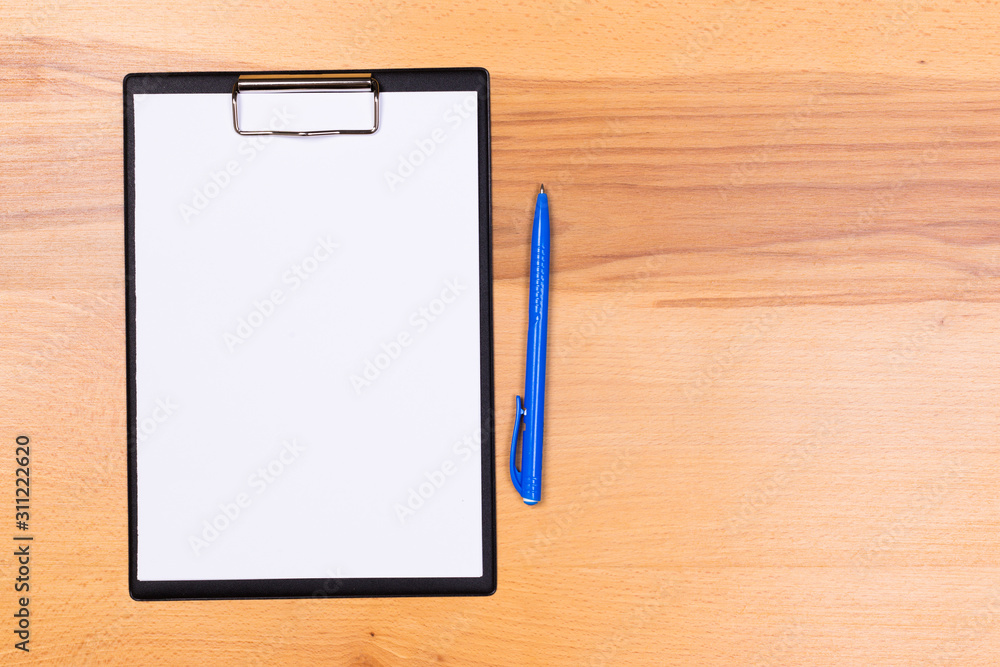 pen on blank white document sheet on wood clipboard on white wood table top view space pen on blank white document sheet on wood clipboard on white wood table top view space