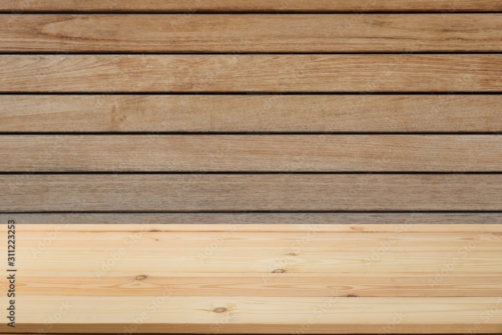 Fototapeta premium Wooden board in front of a blurred background. Perspective brown wood with a blurry background of nature or park - can be used to showcase or assemble your products. Mock up to display the product.
