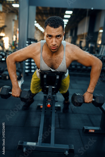 Man doing exercise with dumbbells on the bench © Nomad_Soul