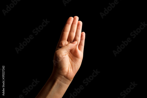Hand Showing Sign of B Alphabet in American Sign Language (ASL), isolated on black background. Sign language