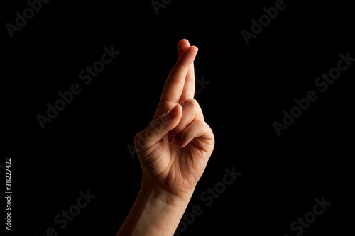 Hand Showing Sign of R Alphabet in American Sign Language (ASL), isolated on black background. Sign language