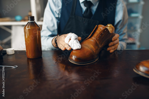 Cuadro en lienzo Shoemaker wipes black shoe polish, footwear repair