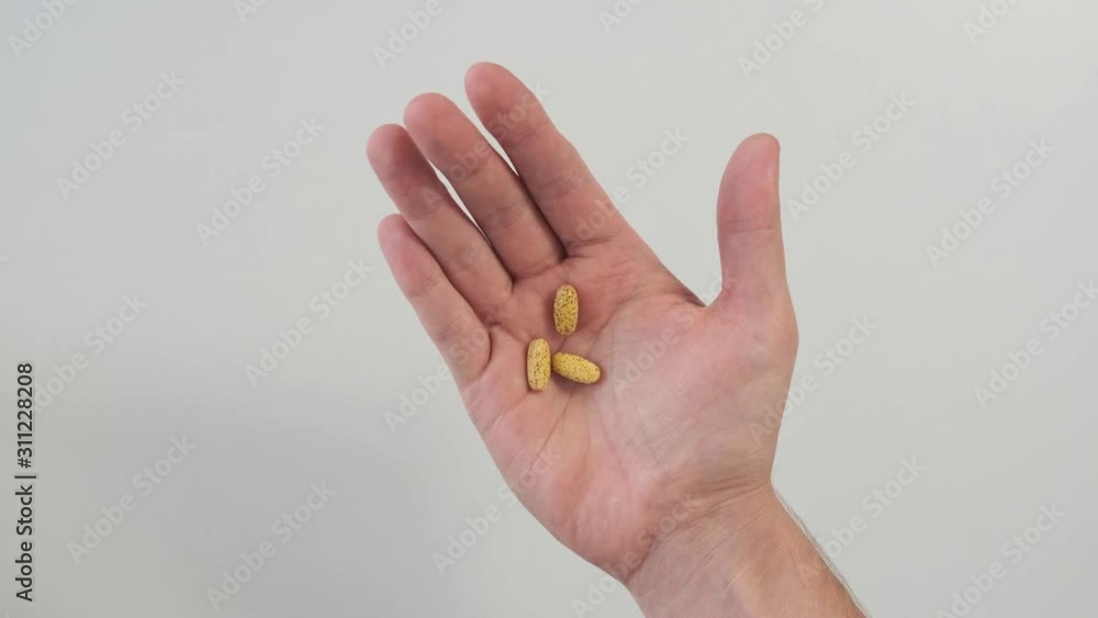 Close-up of male hand with pills. A man puts different pills in his hand. Close-up of male hand with pills. A man puts different pills in his hand.