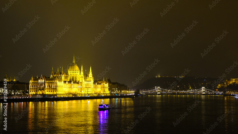 Panoramic view on illuminated Hungarian Parliament building and Chain Bridge at night. Budapest, Hungary