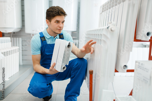 Plumber shows heating radiator section, plumbering photo