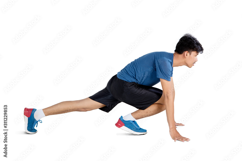 Side view of man crouching and preparing to run Side view of man crouching and preparing to run