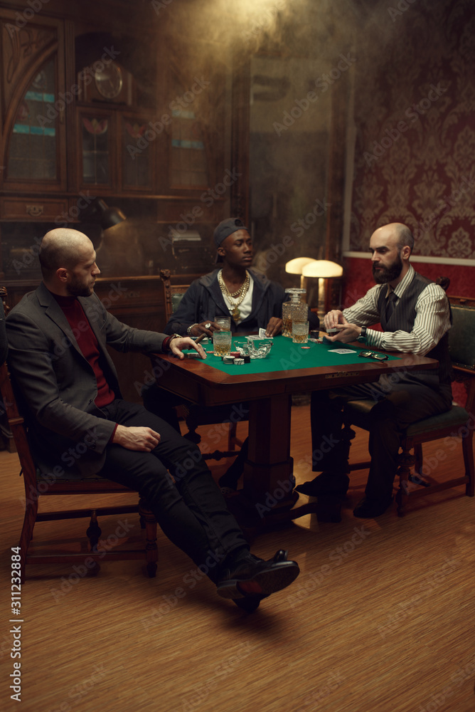 Poker players with cards and chips in casino Poker players with cards and chips in casino